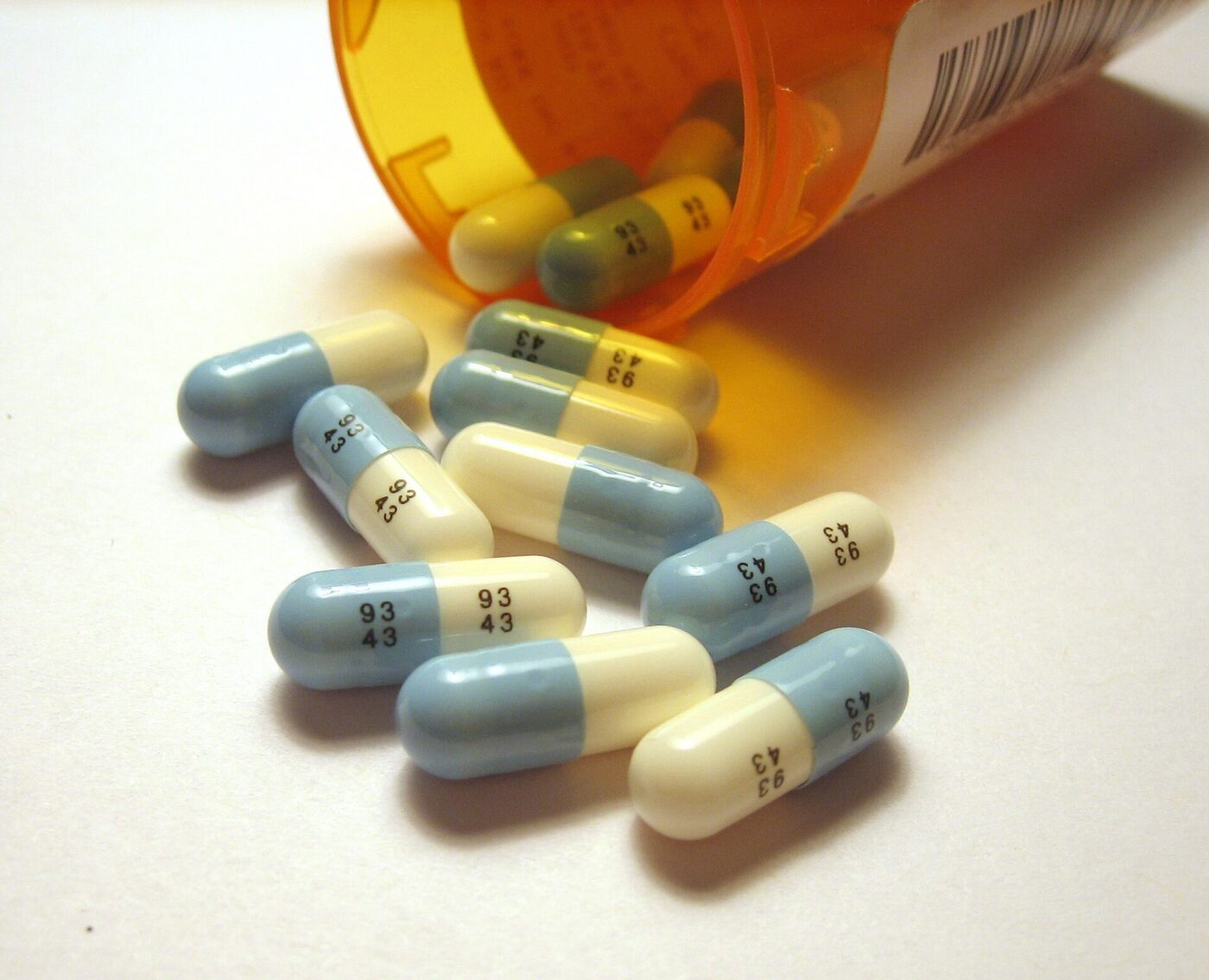 Green and cream Prozac fluoxetine capsules against a plain background.