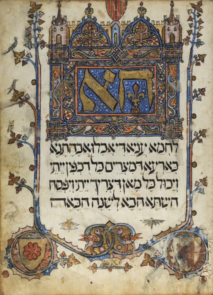 An illuminated manuscript page: a large gilded Hebrew word set in a Gothic architectural frame, four lines of Hebrew text beneath it, and an ivy-leaf border running down both margins to two heraldic shields at the foot.
