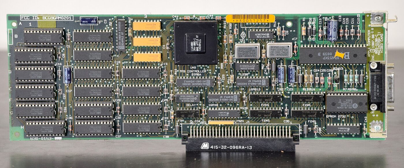 A green expansion card densely populated with chips, with a video connector bracket at one end and an edge connector along the bottom.
